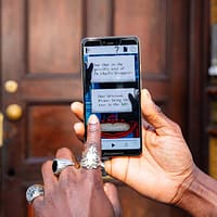 A man is holding up a smartphone. A puzzle from the Dr Jekyll and Mr Hyde London tour is visible on the screen