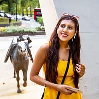 A young woman in a yellow dress is exploring the animals in war memorial in London