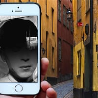 A hand is holding a mobile phone with a sketch of a man in black and white.
