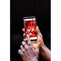 A close-up of a man's hands holding a smartphone. On the screen, an animated scene is visible