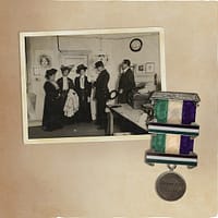An old album with a photo of a group of women and a medal in the suffragette colors