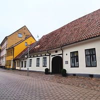 A photo of the Jakob Nilsgatan street in Malmö. The houses are one-storey buildings in different colors.