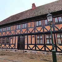 A photo of the Faxeska building in central Malmö. It is a half-timbered house with red brick and black beams.