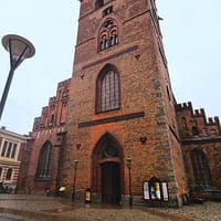 A photo of the St Petri church in Malmö. It's a big red brick building with a gothic look.