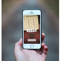 A close up photo of a smartphone. There is a cipher code puzzle with strange symbols on the screen.