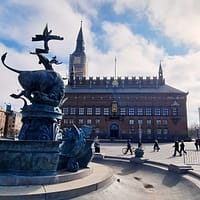 A photo of Rådhuspladsen sqaure in Copenhagen, with the imposing city hall building in the background.