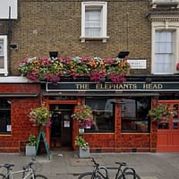 A photo of the exterior of Elephant's Head Pub in Camden. There are colorful flowers decorating the walls.