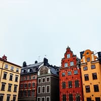 A photograph of a Stockholm Old town skyline, with colorful mortared buildings.