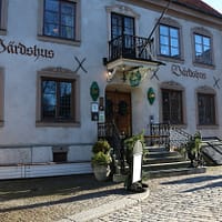 An exterior photo of the Lindgården Inn in Visby. It's a white mortared building on a cobblestone street.
