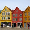 A photo of the Bergen harbour walk. Colorful wooden buildings are crowded along the waterfront.