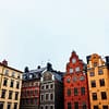 A photograph of a Stockholm Old town skyline, with colorful mortared buildings.