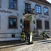 An exterior photo of the Lindgården Inn in Visby. It's a white mortared building on a cobblestone street.