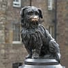 A photo of the Greyfriars Bobby statue. with its snout polished by people petting it over many years.
