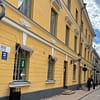 A photo of a street in Helsinki, with yellow mortared buildings lining a cobblestone street.