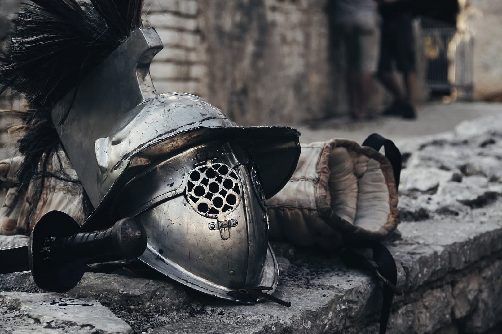 A medieval helmet and glove are placed on a stone step