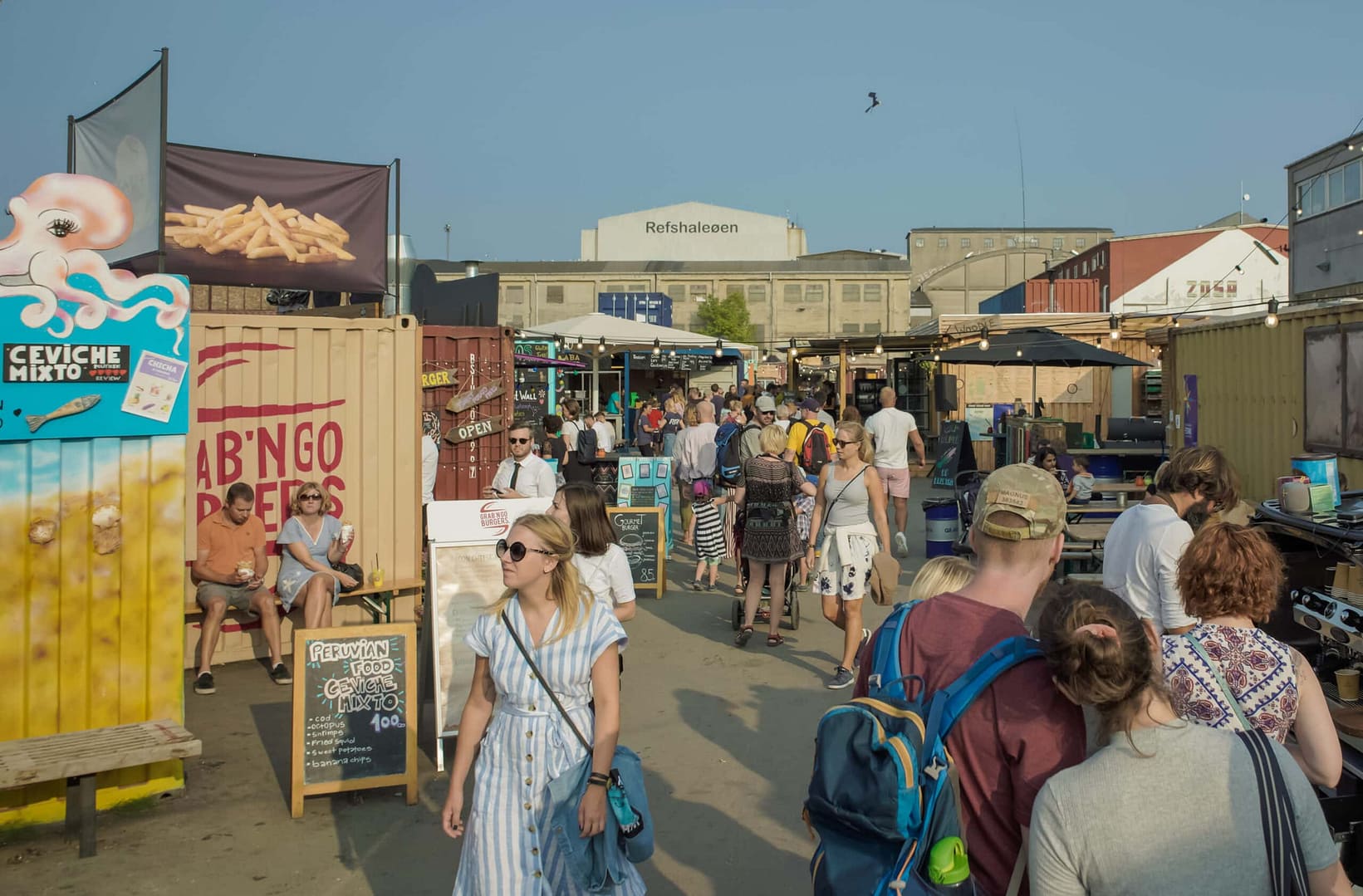 An outdoor market bustling with people on a nice summer day