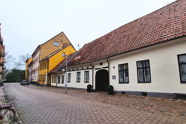 A photo of the Jakob Nilsgatan street in Malmö. The houses are one-storey buildings in different colors.
