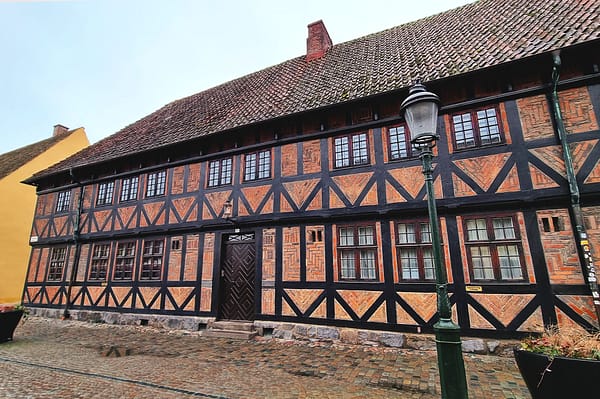 A photo of the Faxeska building in central Malmö. It is a half-timbered house with red brick and black beams.