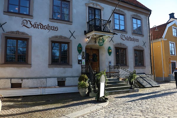 An exterior photo of the Lindgården Inn in Visby. It's a white mortared building on a cobblestone street.