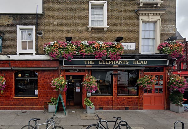 A photo of the exterior of Elephant's Head Pub in Camden. There are colorful flowers decorating the walls.