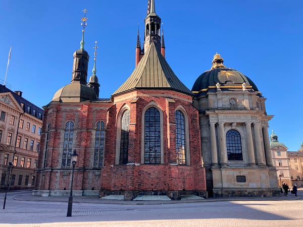 A photo of the Riddarholmen church in Stockholm. It is an imposing red brick building with several large towers.